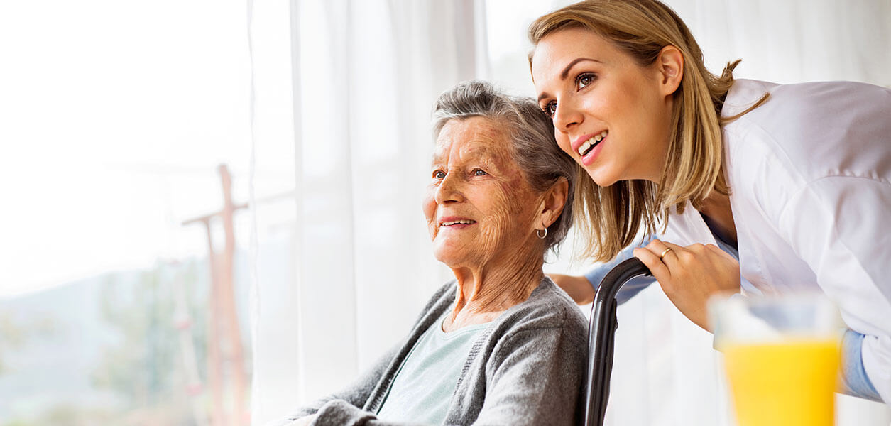 Woman and senior woman looking out window