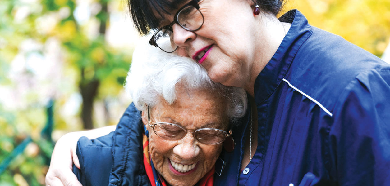 Woman hugging older woman