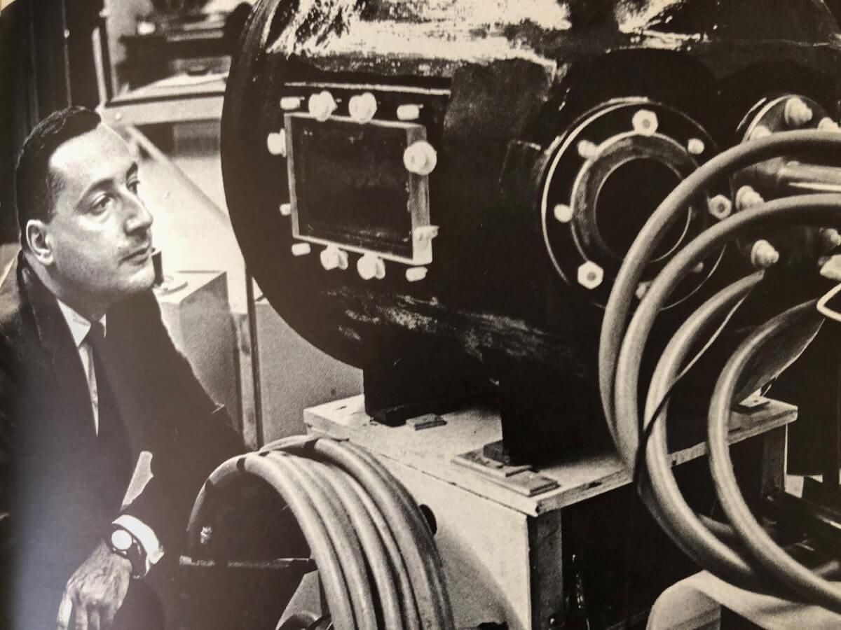 Old photo of man looking at engine