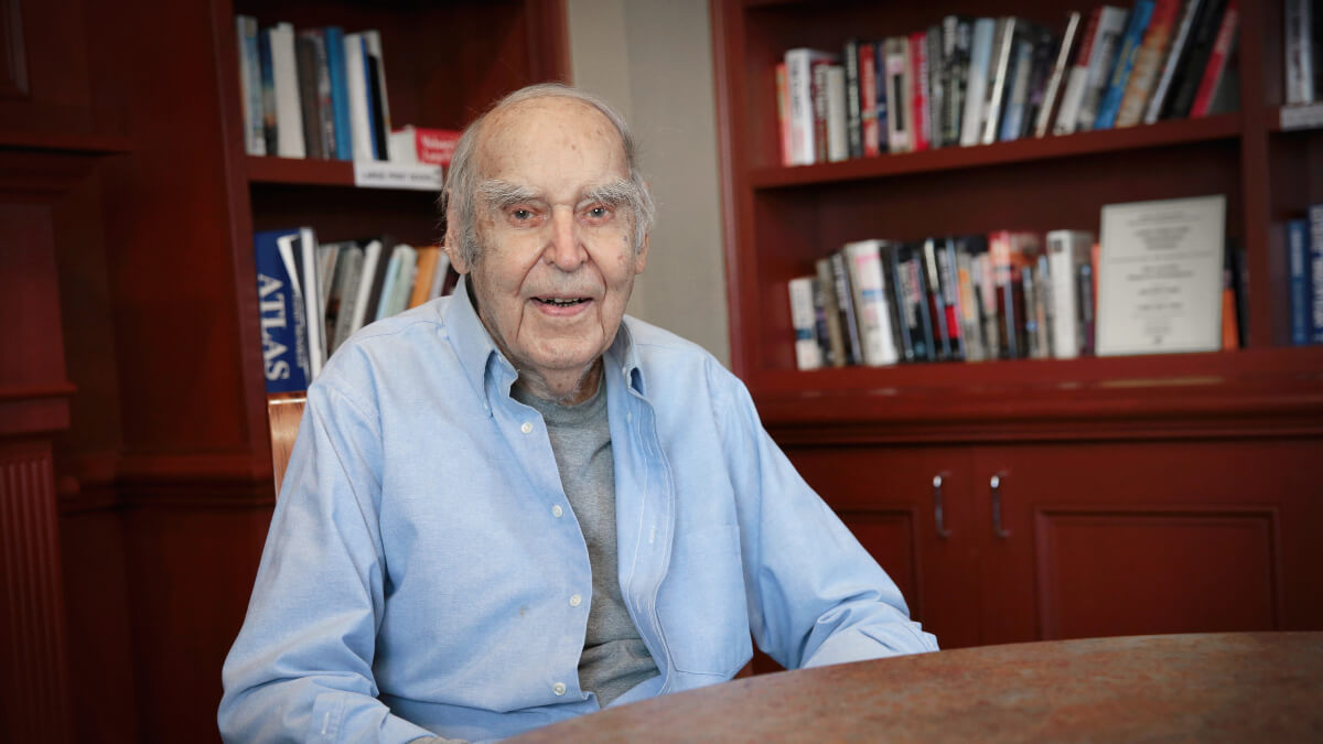 Senior man posing for photo in library room