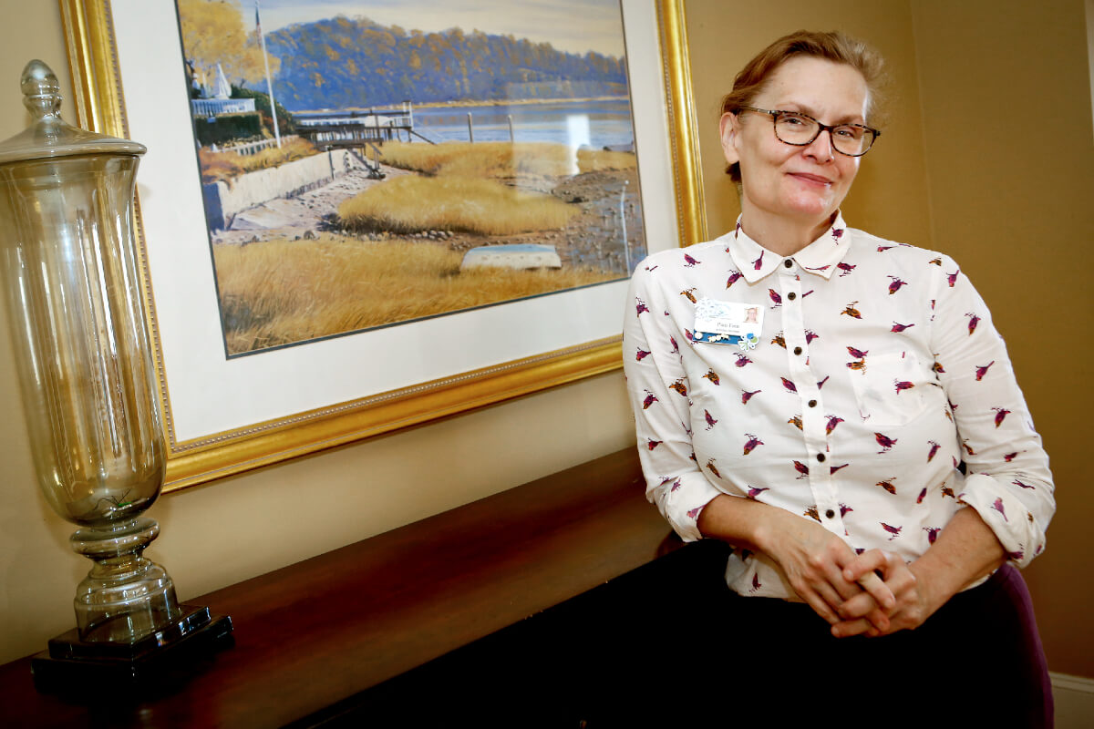 Woman posing for photo in front of painting