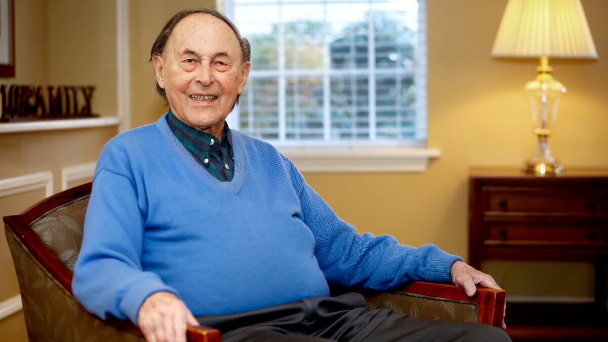 Older man posing for photo in senior home