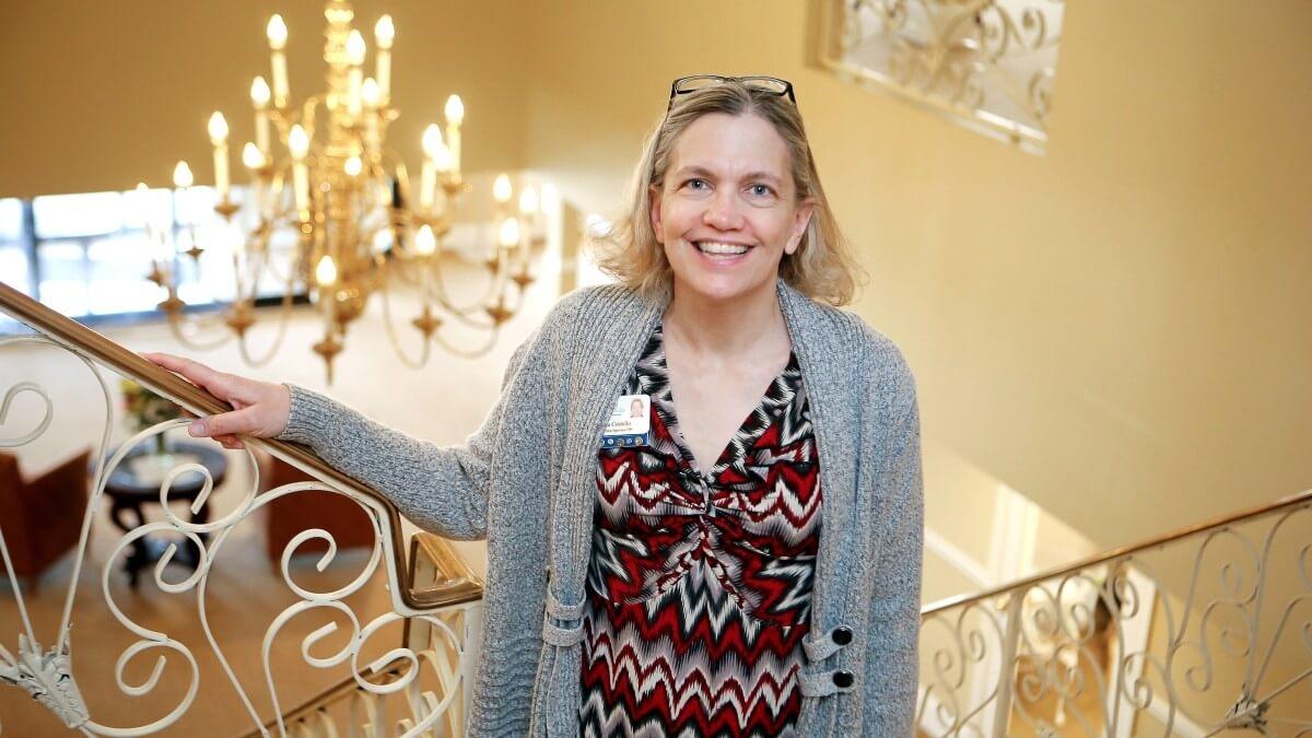 Woman posing for photo in front of staircase