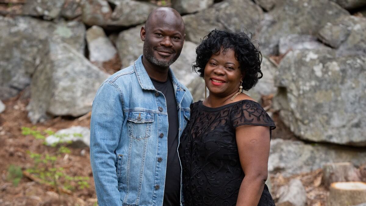 Man and woman posing for photo outdoors