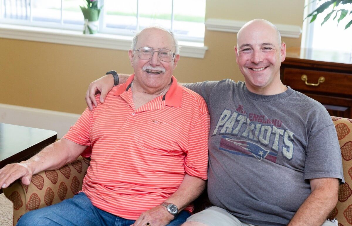 Adult father and son posing for photo