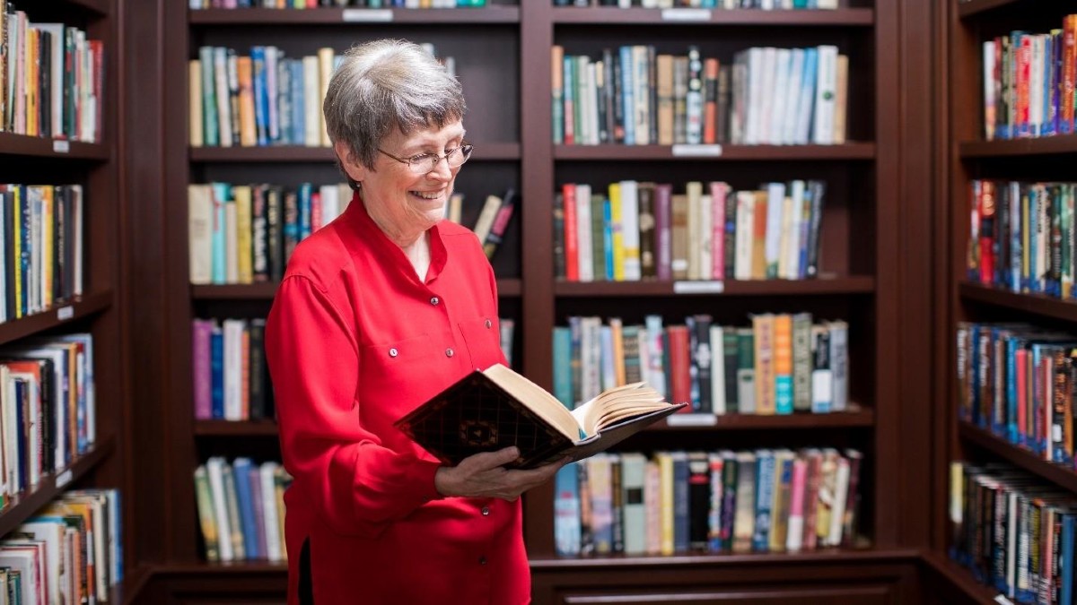 Woman reading book in library