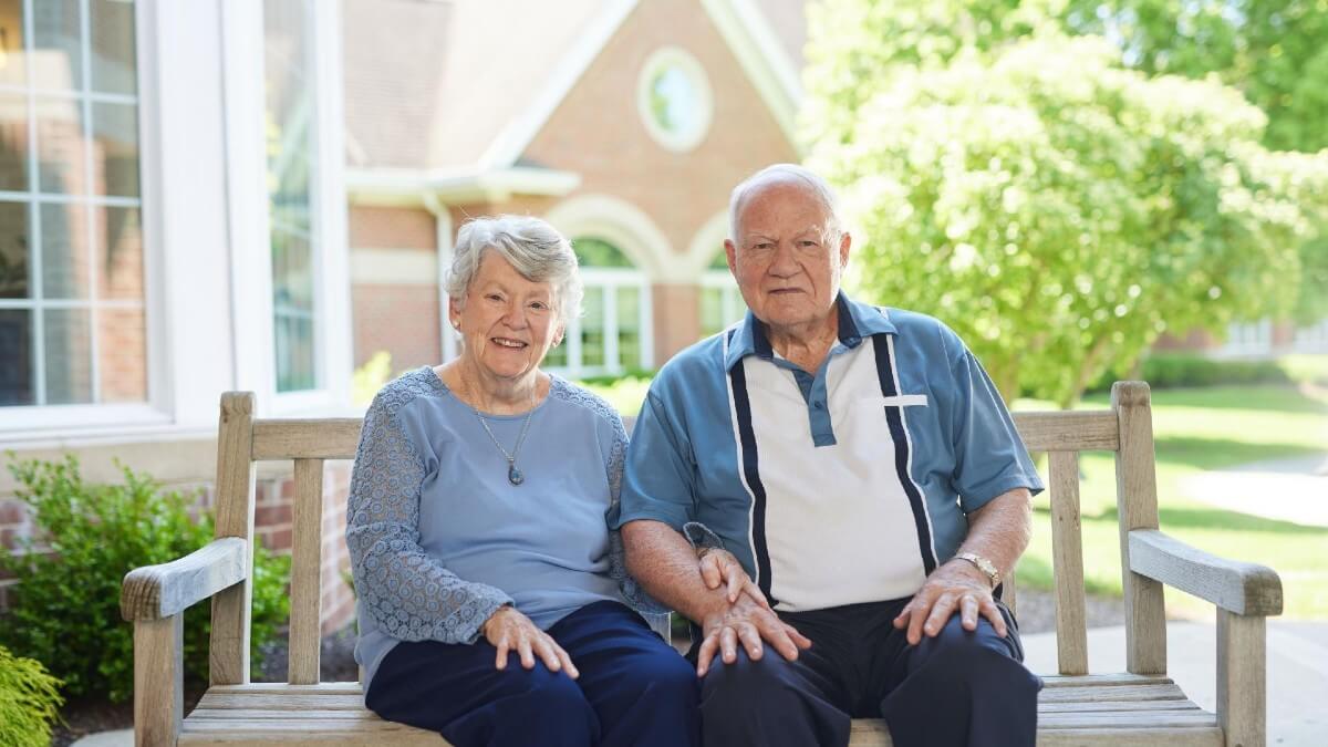 Senior couple sitting on bench outdoors