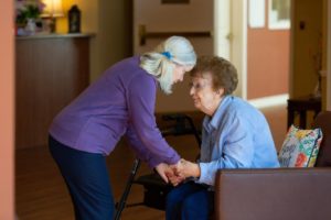 Older woman and senior woman holding hands