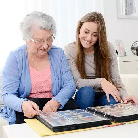 Senior woman and young woman looking at photo album