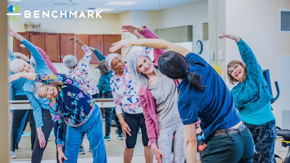 a group of residents reaching over in an exercise class