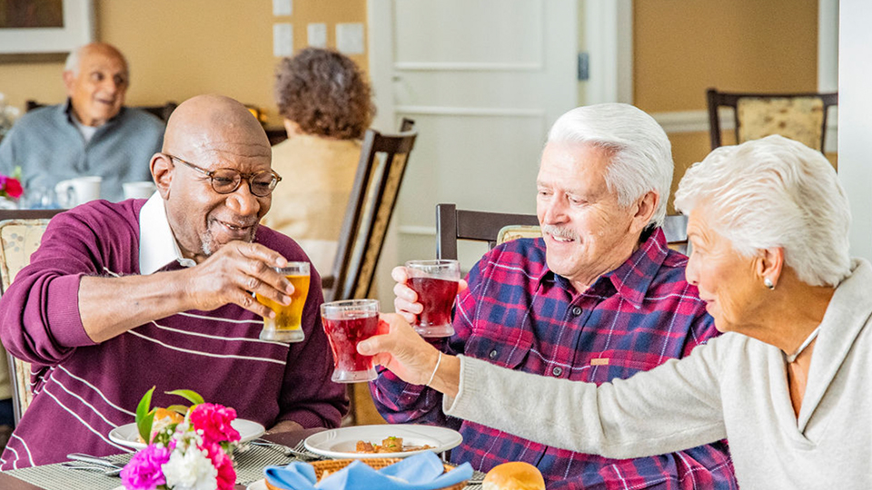 Three senior men raising beer glasses