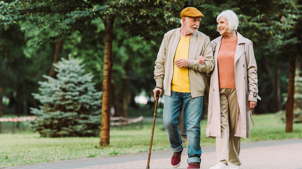 An older man and woman walking arm in arm