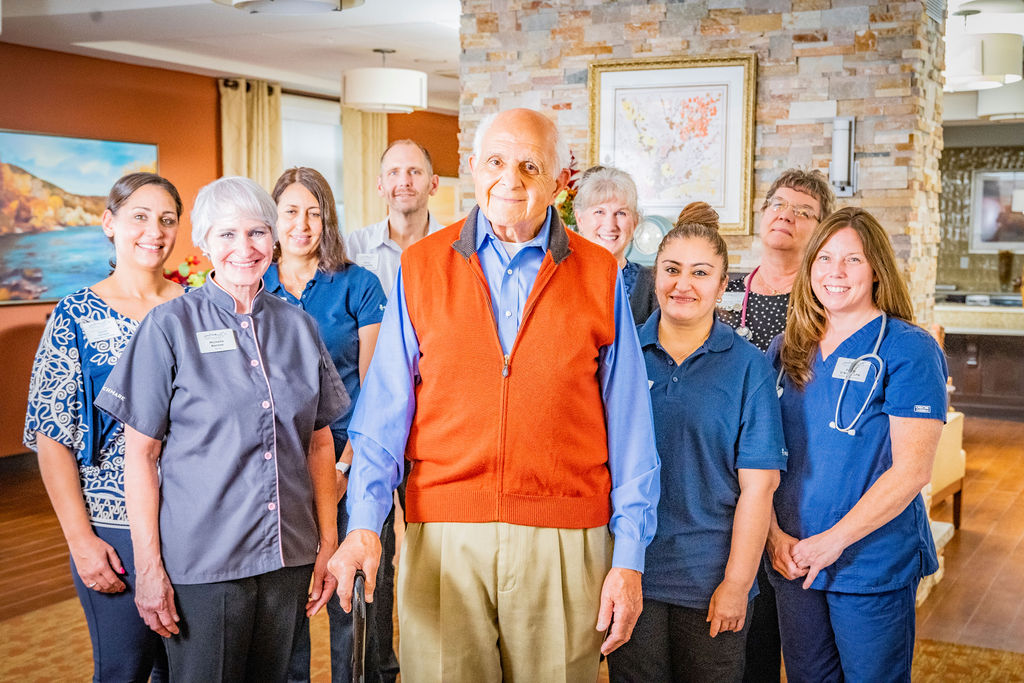 a senior man with senior living associates standing behind him