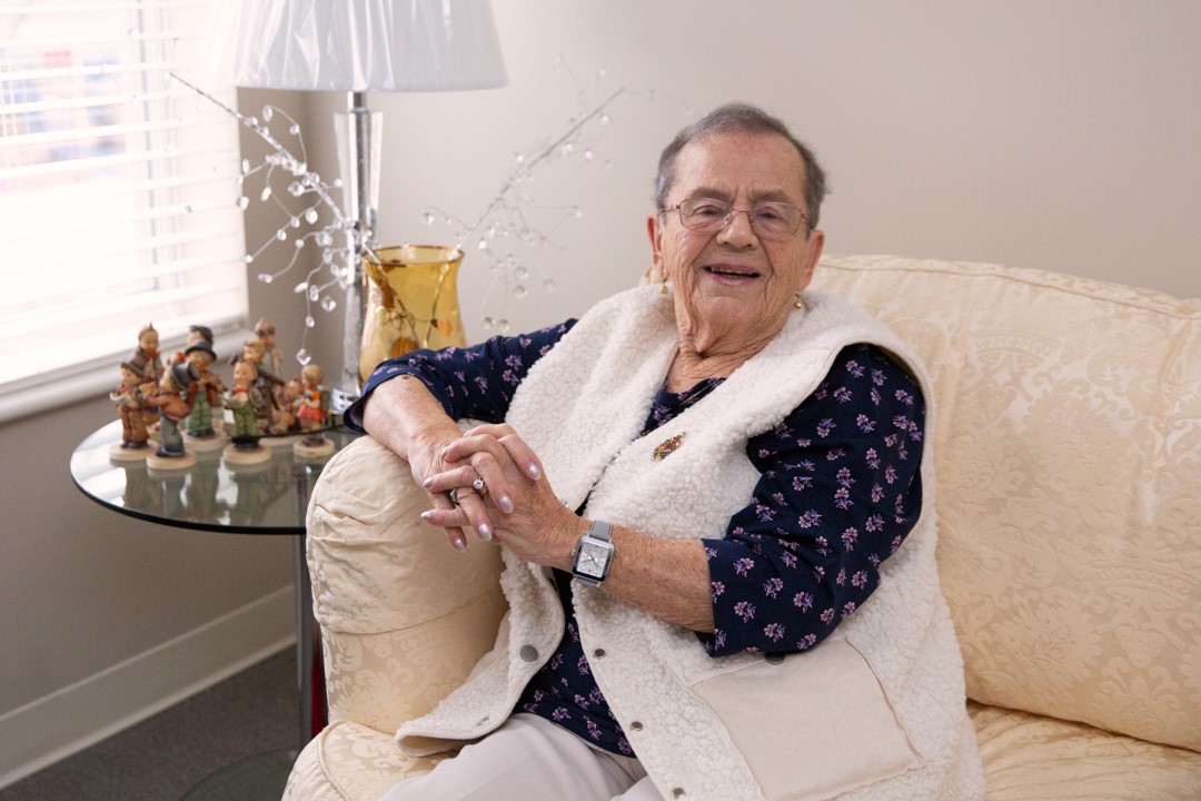 a woman sitting and smiling on her couch