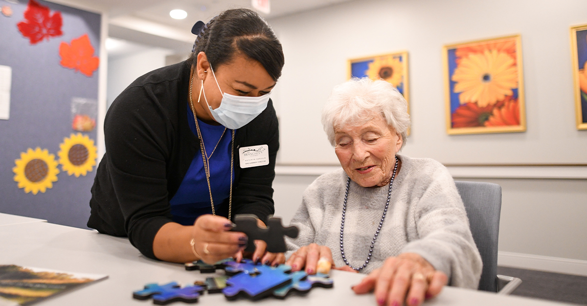 a senior woman and an associate working on a jigsaw puzzle