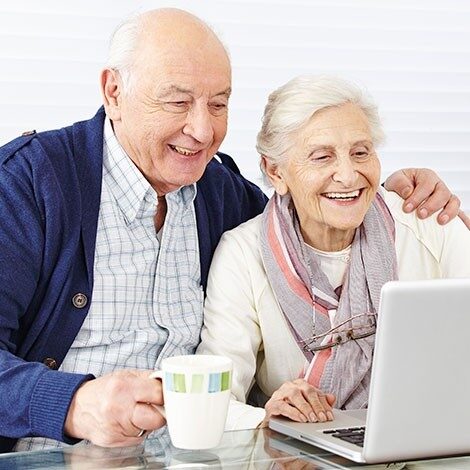Living & Care Pricing Senior man and woman using laptop