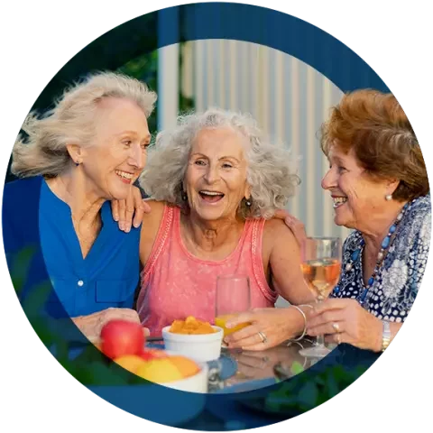 Group of older women laughing during a meal