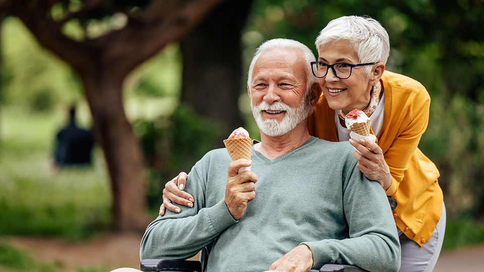 an older man and woman enjoying ice cream cones