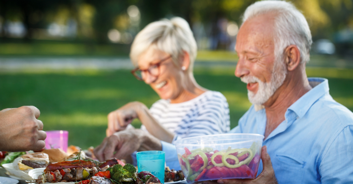 Older couple enjoying a BBQ outside