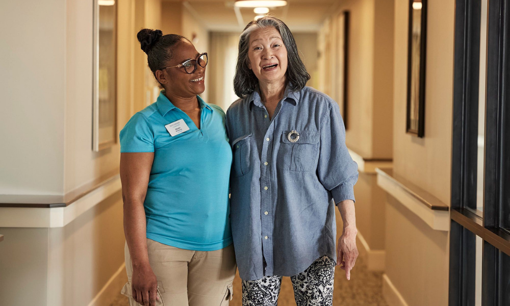 an associate and an older woman standing, smiling