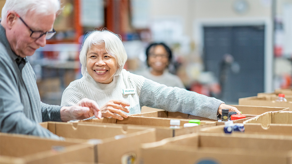a senior smiling while at a volunteer event