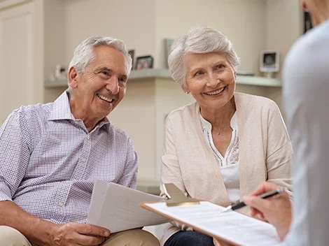 AL_costofcare.png Older man and woman discussing finances with nurse