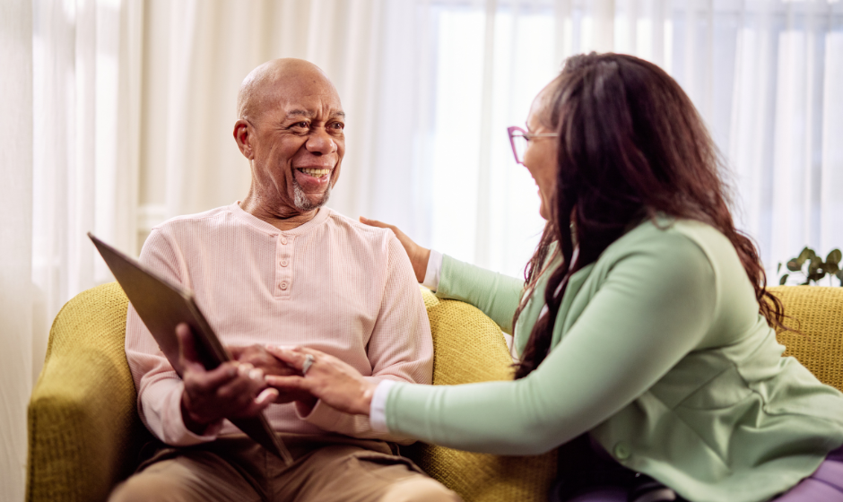 A woman with her arm on a man's shoulder, smiling